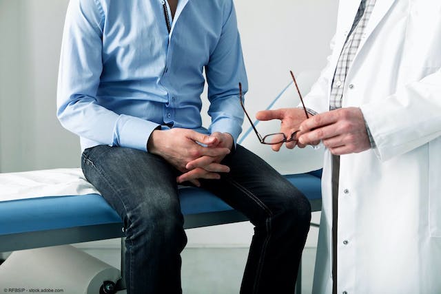 man sitting in hospital room talking with a doctor